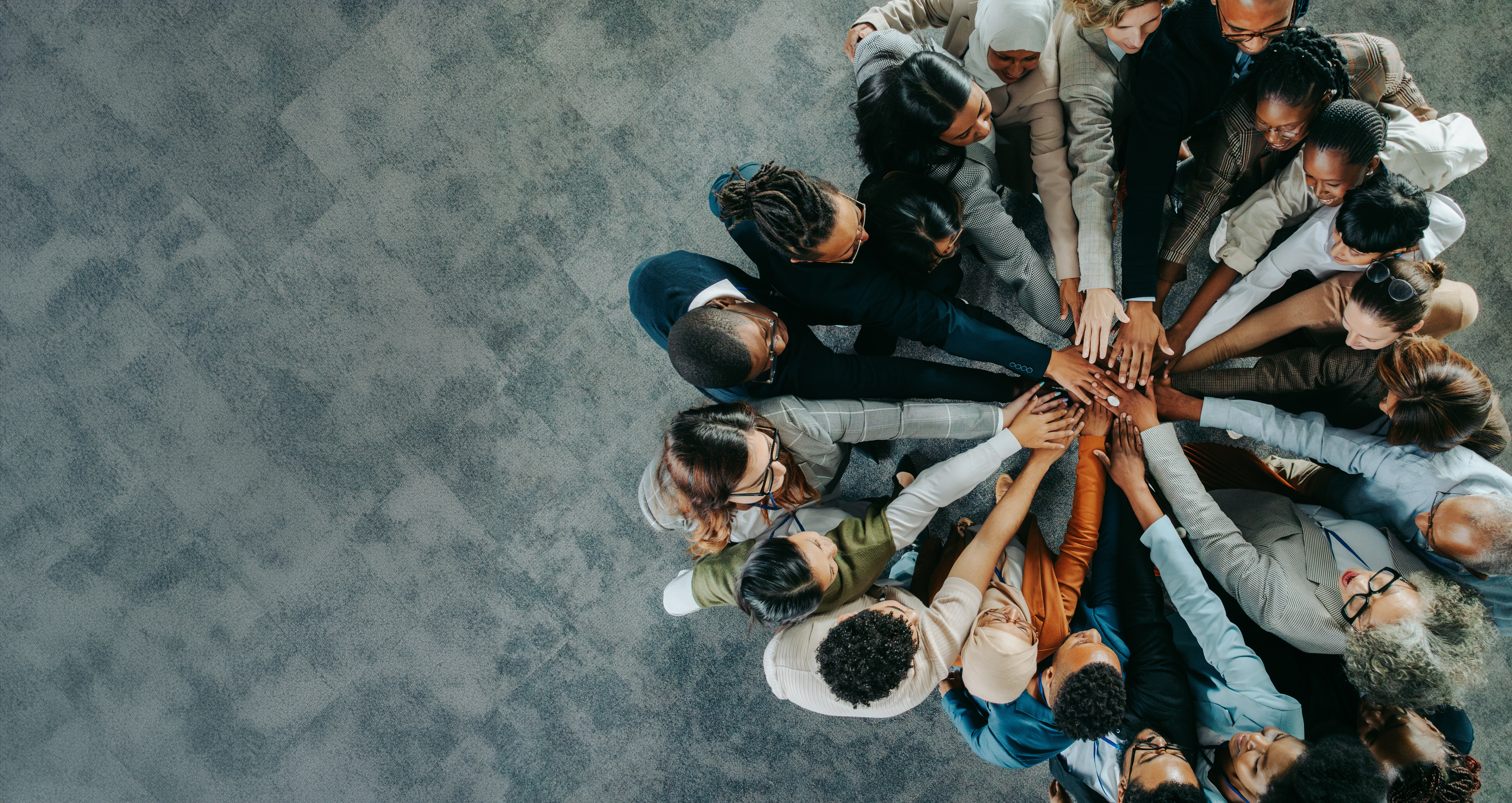 Top view of a diverse business team with colleagues putting their hands together, symbolizing unity, teamwork, and collaboration.