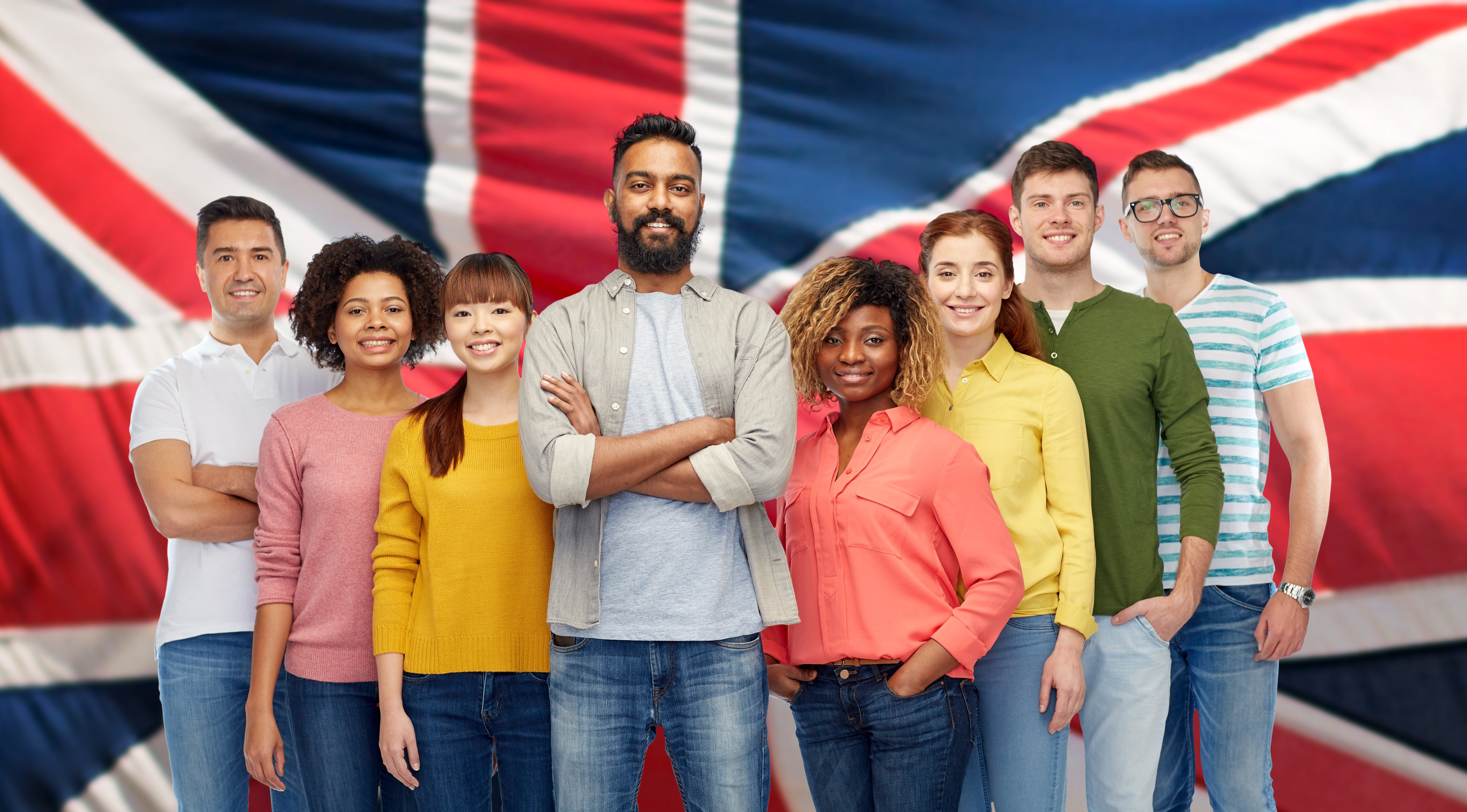 diversity, race, ethnicity and people concept - international group of happy smiling men and women over british or english flag background