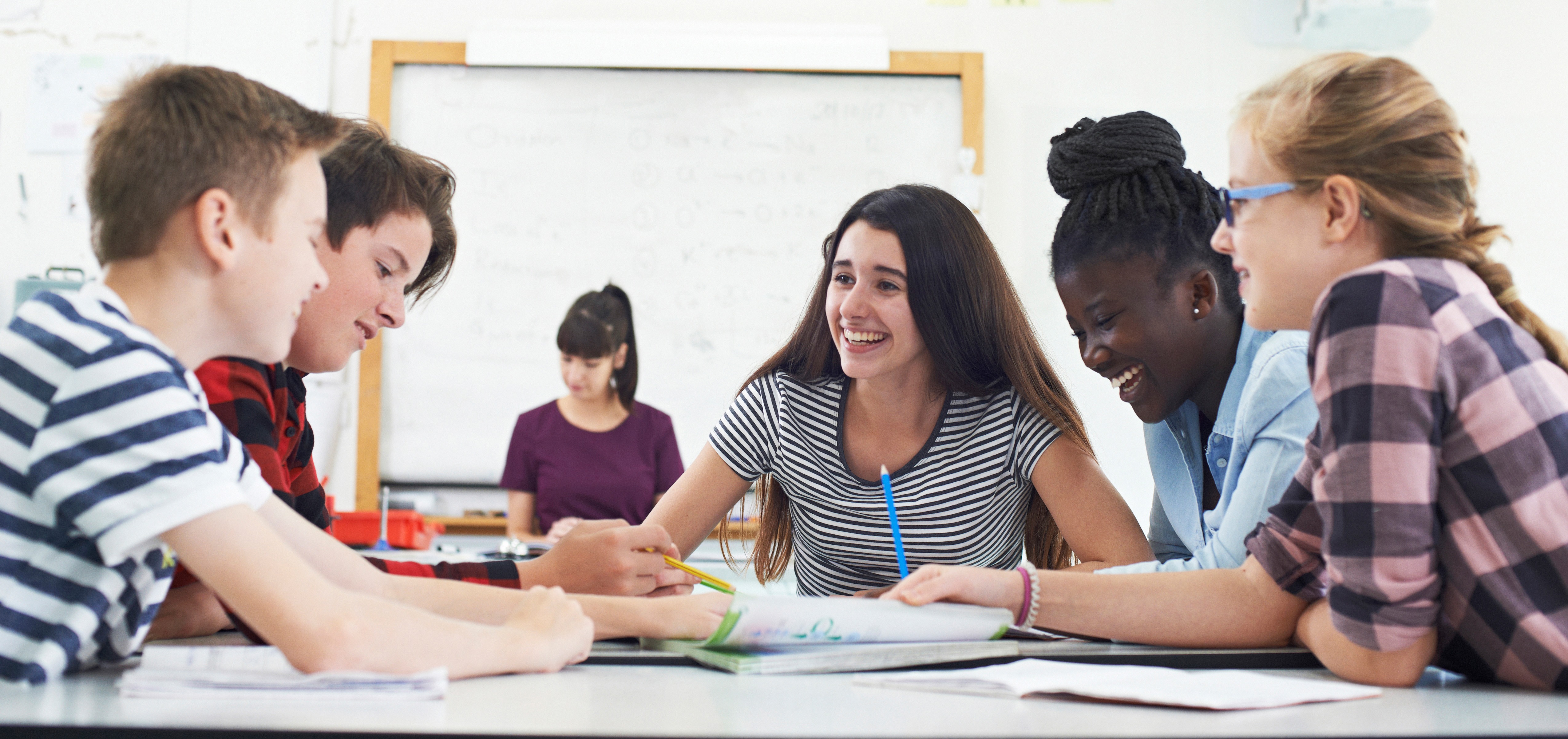 Group Of Teenage Students Collaborating On Project In Classroom