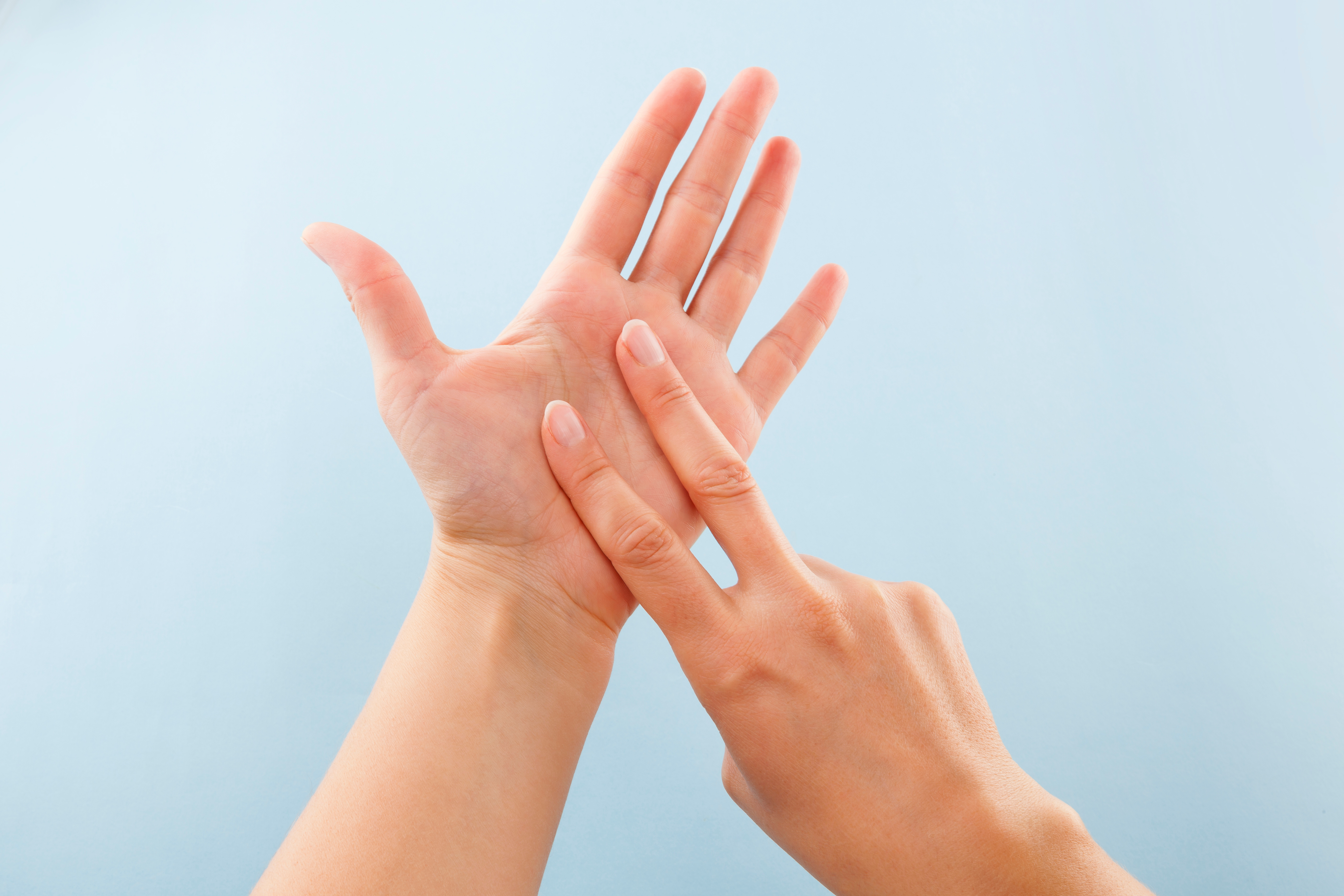 Fingerspelling alphabet. Female hands isolated on blue background showing deaf mute BSL alphabet letter V.