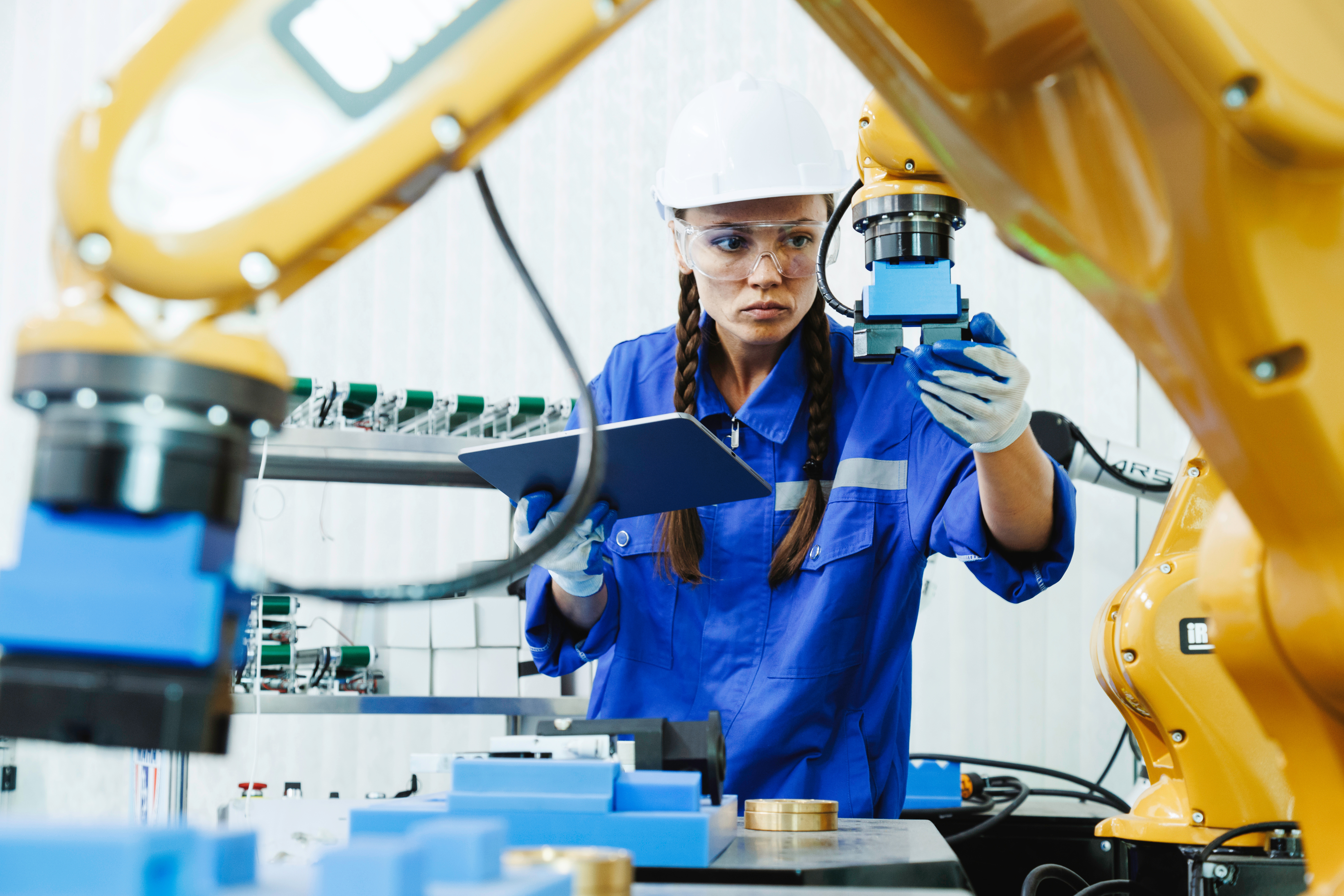 female automation machine engineer student study and inspection control robot arm machine in university or factory workshop. AI robot technology are new innovation trean for manufacturing in industry 5.0